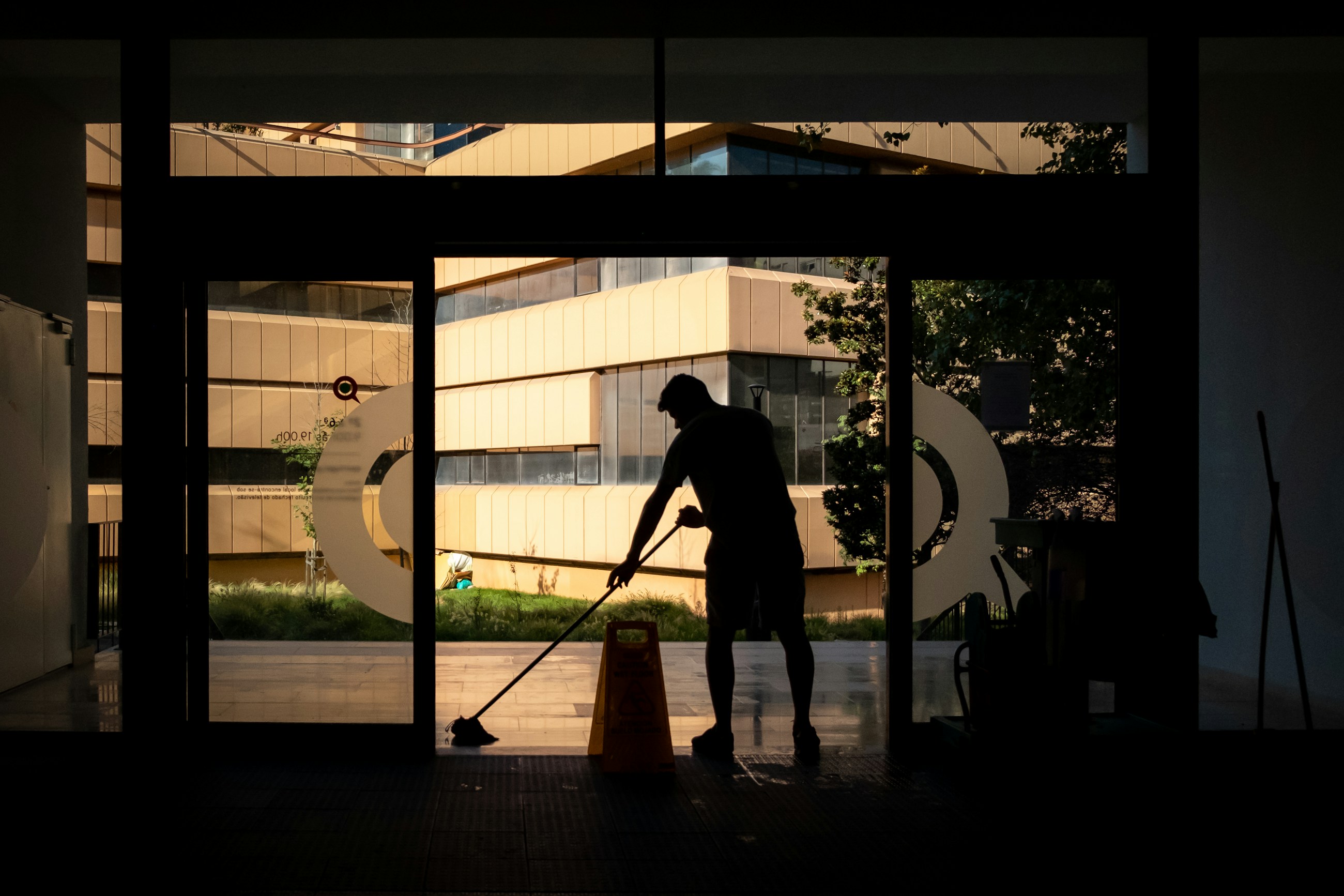 Professional cleaner mopping the entrance of a commercial property